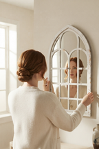 Miroir fenêtre cintrée, 25×45 cm. En situation, présence humaine suggérée de dos.