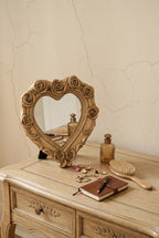 Miroir cœur roses sculptées, 14×13,8 cm. Présenté avec un objet de référence pour l'échelle.