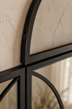 Détail macro du cadre en métal noir mat et du verre trempé de la verrière arquée