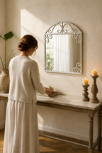 Femme de dos près de l'arche à volutes blanc vieilli, console d'entrée en lumière du matin