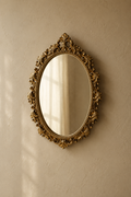 Miroir ovale, ruban et fleurs dorés 20×27 cm, monté seul sur un mur en plâtre chaud.