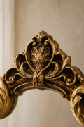 Miroir écusson, couronne dorée 20×29 cm, gros plan sur la couronne sculptée en haut du cadre.