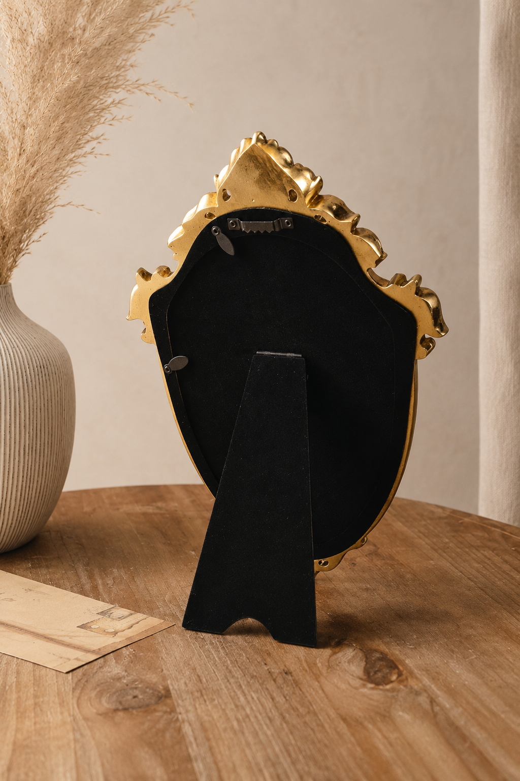 Miroir écusson, couronne dorée 20×29 cm, vue arrière avec patte d'accroche murale et pied-support articulé.