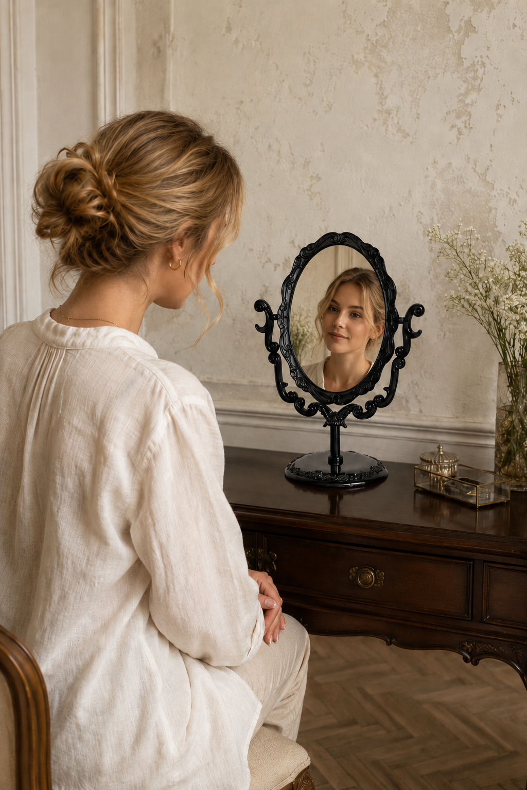 Miroir coiffeuse papillon, noir 22×16 cm. En situation, présence humaine suggérée de dos.