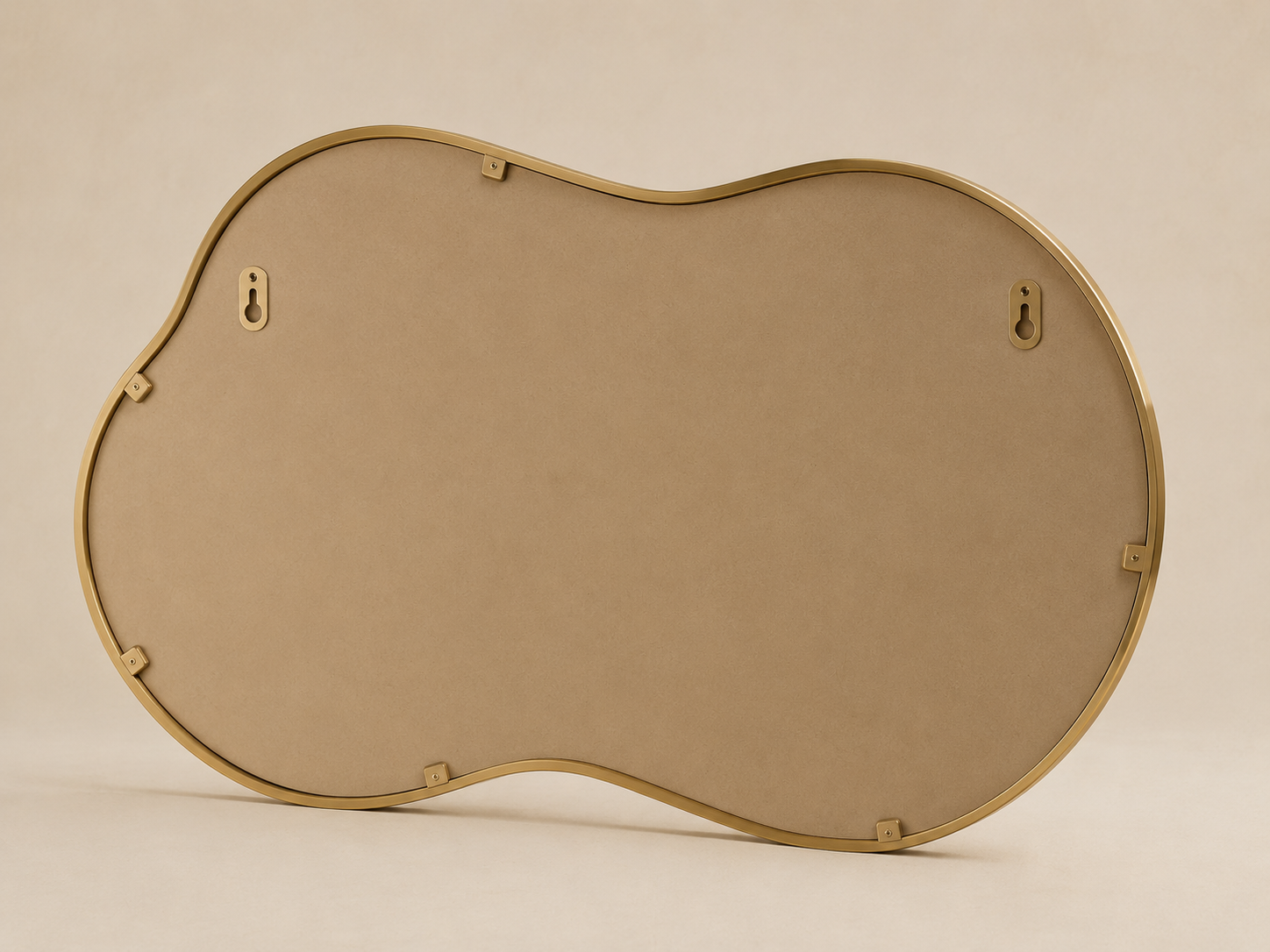 Miroir nuage asymétrique 116×66 cm, Disponible en noir ou doré, contour organique ondulé. Vu de l'arrière ou en cours d'installation.