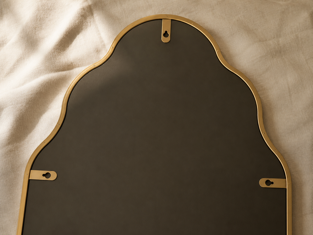 Miroir lanterne asymétrique 116×66 cm, Disponible en noir ou doré, silhouette galbée verticale. Vu de l'arrière ou en cours d'installation.