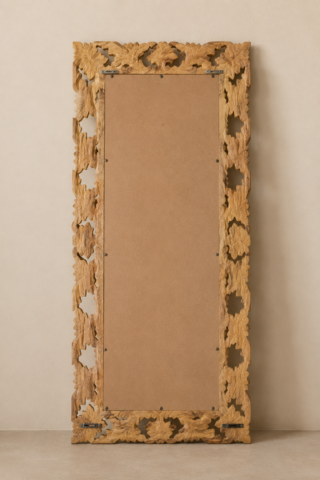 Miroir sculpté en bois de manguier 50x110 cm, Brut naturel, motif feuillage ajouré. Vu de l'arrière ou en cours d'installation.
