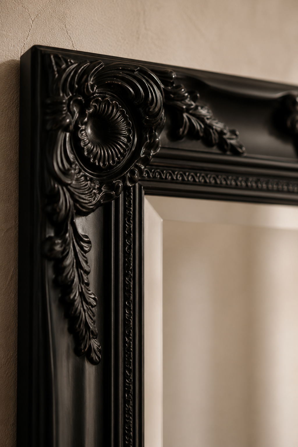 Miroir baroque noir 100x50 cm, Noir laqué, motif baroque sculpté. Détail du cadre en gros plan.